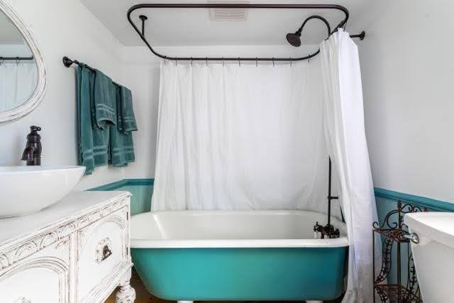 A bathroom featuring a blue and white bathtub complemented by neutral colored walls and modern fixtures