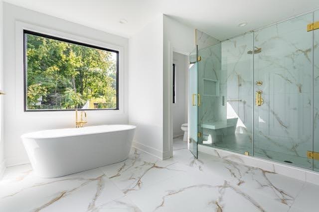 A bathroom featuring elegant marble flooring and pristine white walls creating a clean and modern aesthetic