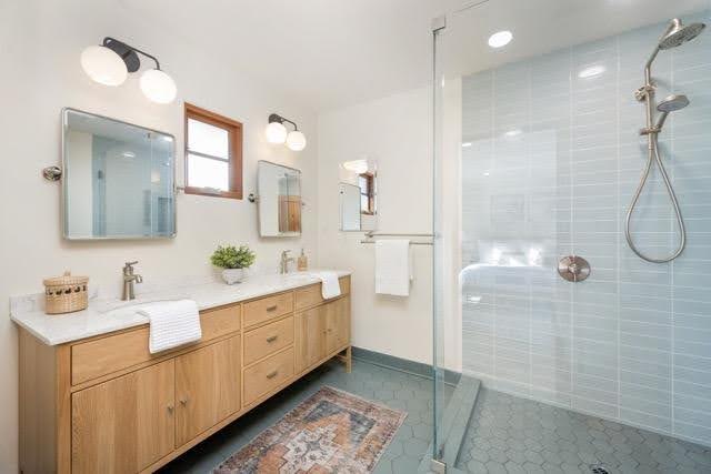 A stylish bathroom with a blue tiled floor and elegant wooden cabinets enhancing the overall design