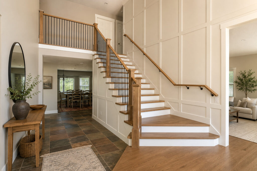 A wooden staircase in a home featuring polished wood floors and clean white walls